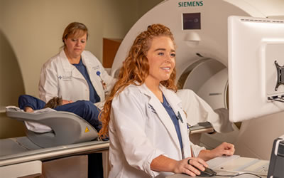 Patient care technicians guide a patient through a cardiac PET imaging scan.